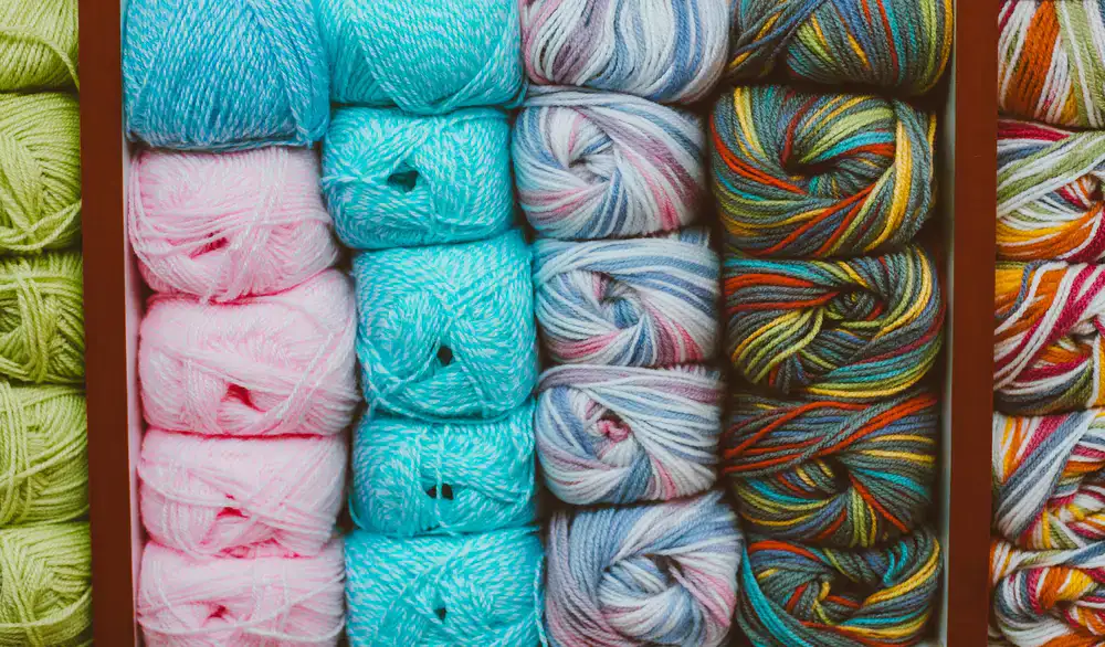 Various colourful yarn skeins stacked neatly